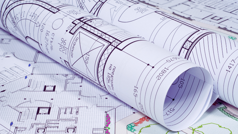 architectural drawings rolled up on a table